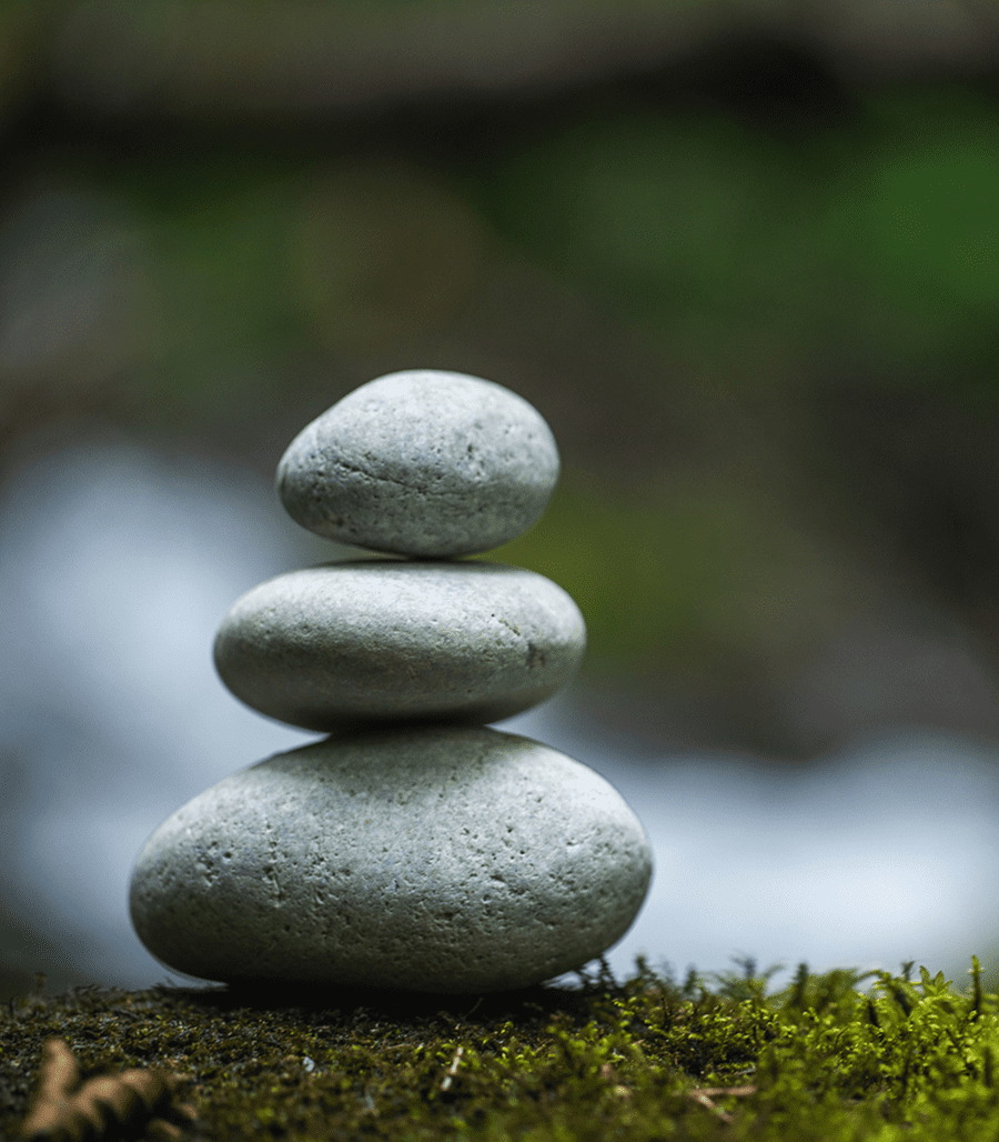 Stacked stones on mossy surface.