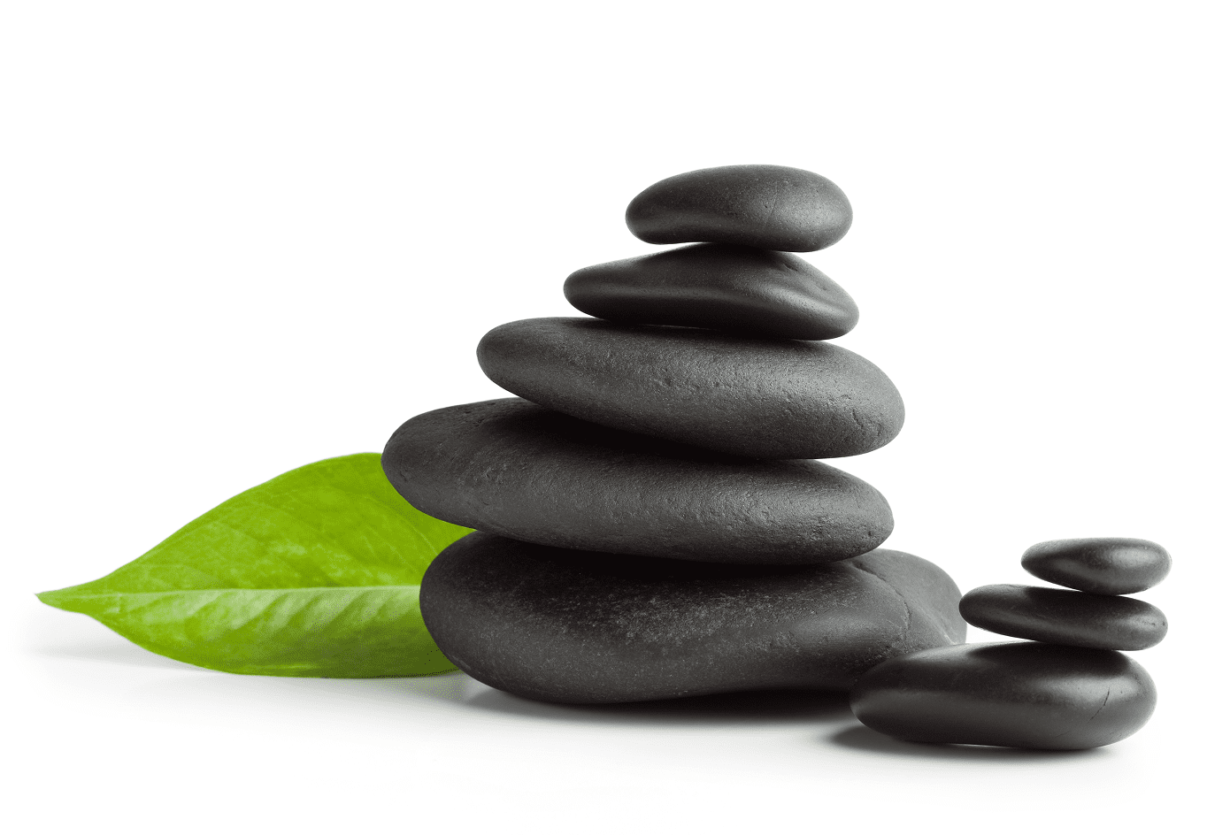 Stacked black stones with green leaf.