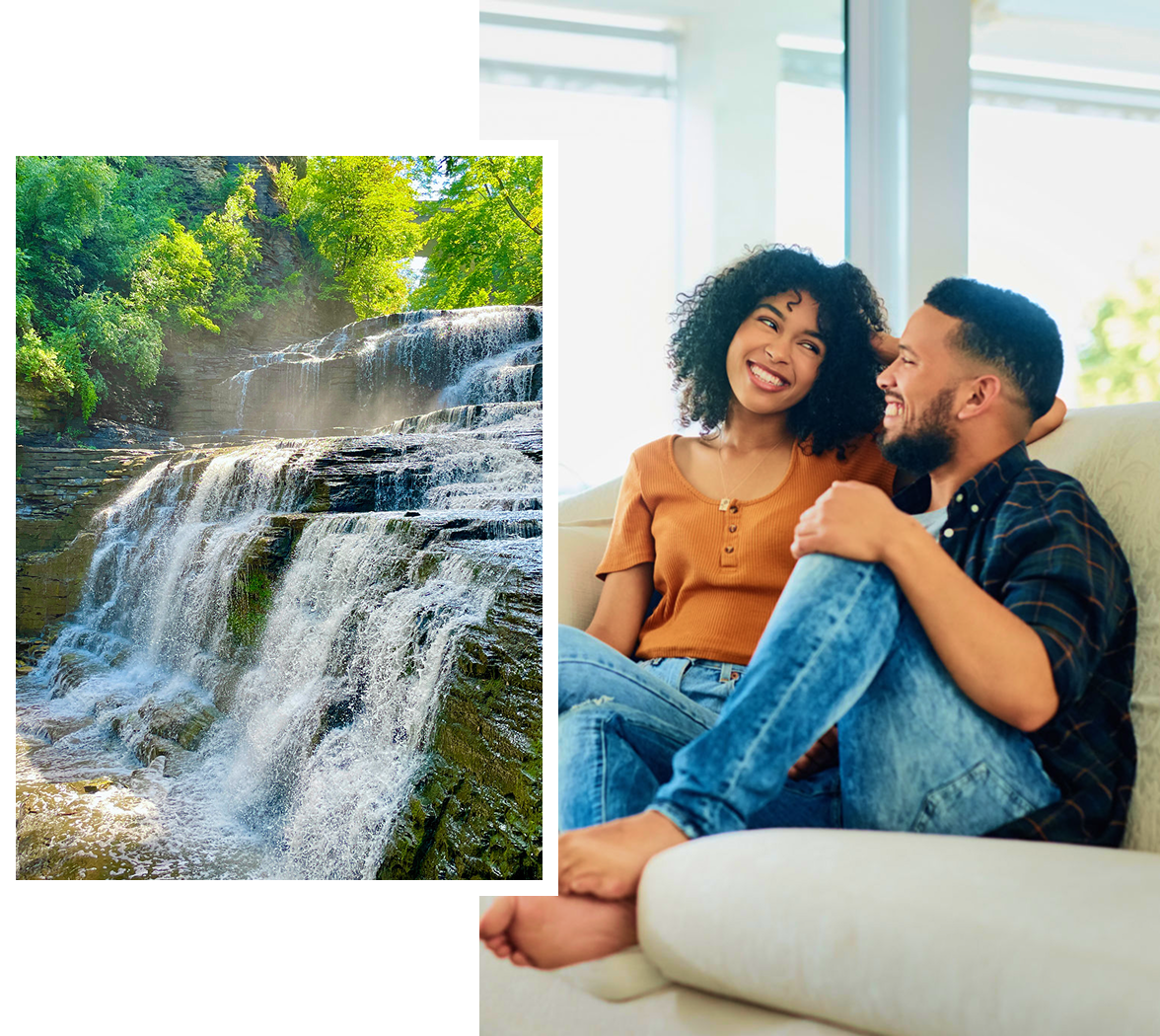 Couple smiling on couch, waterfall in background.